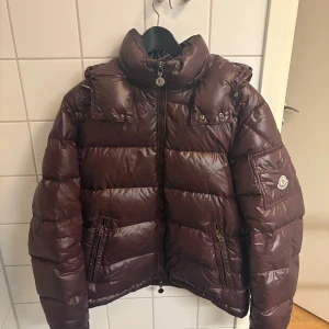 Brun Moncler dunjacka - moncler maya i fint skick, inga hål eller liknande, tyvär fattas bilden på insidan av jackan därav är priset lite billigare. digitalt kvitto finns och äktahets bevis ifrån vestiaire finns