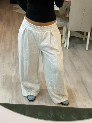 Gråa baggy mjukisbyxor - Säljer ett par helt nya oanvända gråa mjukisbyxor med loose fit och bred resår i midjan ifrån Bohoo. Byxorna har raka ben och är tillverkade i mjukt bomullsmaterial. Köptes för 499kr. Jag är 160cm och de är i storlek M. 