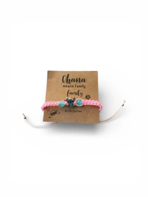 Rosa flätat armband med pärlor - Ett rosa flätat armband med turkosa och blå pärlor samt en liten metallcharm i mitten. Justerbar knytning för perfekt passform. Perfekt accessoar för dig som gillar färg och personliga detaljer.