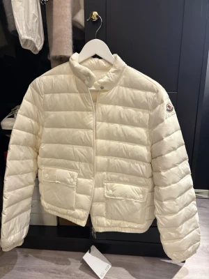 Moncler jacka - Vit monclerjacka med prislapp på, helt ny. Kan inte garantera autencitet. Qr kod finns dock.