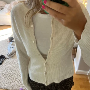 Vit kofta från & Other Stories XS - Superfin vit kofta från & Other Stories i storlek XS. Koftan är stickad med en mjuk känsla, har långa ärmar och knäpps med knappar framtill. Den är väl använd så man ser att plagget är använt 