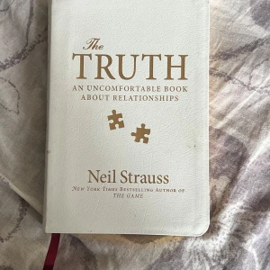 The Truth: An Uncomfortable Book About Relationships - En snyggt designad bok med vit läderliknande pärm och guldsnittade sidor. Perfekt för dig som gillar personliga berättelser om relationer och vill läsa något annorlunda och utmanande. Skriven av författaren till The Game.