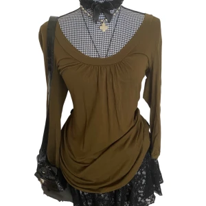 Olivgrön blus<3 - Olivgrön långärmad blus med rynkad detalj vid bysten och rundad halsringning. Passformen är runt M-L men skulle även kunna passa S. Vissa små defekter som lösa trådar och lite nopprig vissa ställen, men syns knappt. Ge gärna prisförslag🖤 OBS❗️ färgen på bilden är inte exakt som på plagget