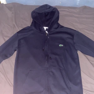 Lacoste hoodie  - Blå lacoste hoodie storlek M PASSAR som S! Helt oanvänd och äkta skickas ut inom 2 dagar av köp