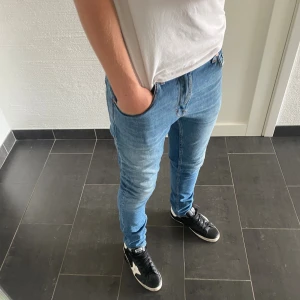 Tiger of Sweden Jeans - Säljer ett par ljusblå skinny jeans från Tiger Of Sweden modell Pistolero. Jeansen har klassisk femficksdesign, snygga slitningar och är tillverkade i Italien. Perfekta för dig som gillar en tight passform och stilren look.