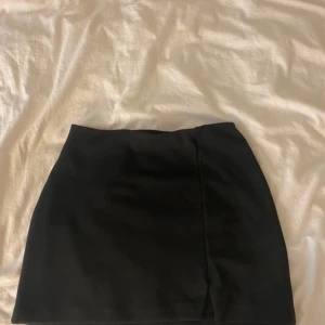 Svart minikjol - Super söt mini kjol ifrån Divided hm. Har en lite slits framtill. Använd några gånger
