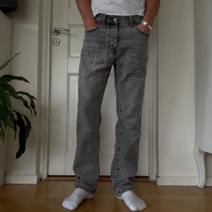Grå jeans straight fit - Säljer ett par grå jeans med klassisk rak passform och femficksdesign. Snyggt tvättad grå färg som passar till allt. Den enda slitningen sitter på vänstra frambenet men syns knappt. Skriv för mått eller fler bilder!