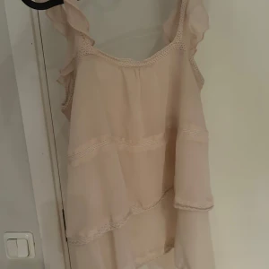Ljusbeige volangklänning Gina Tricot - Supersöt ljusrosa topp  från Gina Tricot med volanger. Nyskick. 