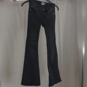 Svarta bootcut jeans med utsvängda ben - Snygga svarta jeans med bootcut och utsvängda ben. Klassisk femficksmodell med dragkedja och knapp framtill. Jeansen har en mörk tvätt och är perfekta för dig som gillar en retroinspirerad look. Xs short