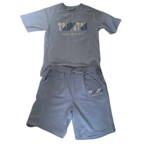 Ljusblå shorts från Trapstar M - Säljer ett par ljusblå shorts från Trapstar i storlek M. De har elastisk midja med snörning och tryckt logga på ena benet. Sköna och stilrena, perfekta för sommaren och chill dagar.