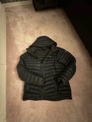  Peak Performance jacka 160 - Svart dunjacka från Peak Performance med huva. perfekt för kyliga dagar. St 160.