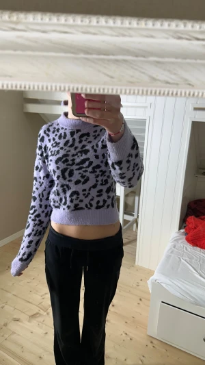 Ljuslila leopardmönstrad croppad tröja från Monki - Superfin ljuslila croppad tröja från Monki med svart leopardmönster. Tröjan har lång ärm, ribbad hals och är gjord i mjuk stickad polyester och akryl. Perfekt för dig som gillar att sticka ut med coola mönster och färger.