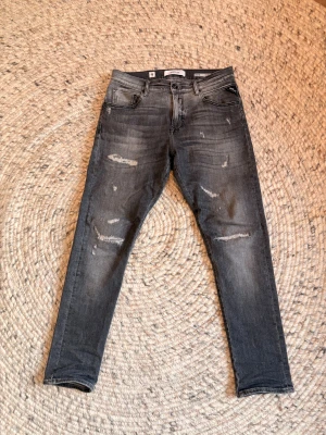 Replay jeans - Säljer ett par Replay MickyM jeans i grå tvätt med slitna detaljer och slim tapered fit. Byxorna har fem fickor, knapp och dragkedja i gylfen samt klassisk Replay-lapp bak. Snyggt smalare ben och coolt sliten look. Storlek 30/30 och priset är inte hugget i sten. Hör av er vid minsta fundering!