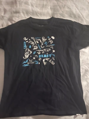 Signerad MrBeast T-shirt - Signerad MrBeast t-shirt. Storlek xs. Perfekt för dig som vill ha en cool unik t-shirt, eller dig som vill ha en värdefull tröja som blivit signerad av världens största youtuber MrBeast. Tröjan är ej använd men har vara uppe som prydnad. Hör av dig vid intresse