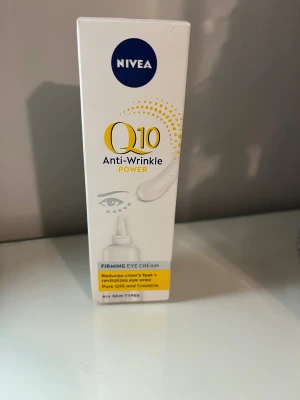 NIVEA Q10 Anti-Wrinkle Power Eye Cream - NIVEA Q10 Anti-Wrinkle Power Firming Eye Cream är en vit ögonkräm i tub med blå och gula detaljer. Innehåller Q10 och kreatin för att minska rynkor, mörka ringar och svullnad runt ögonen. Passar alla hudtyper och ger ett fräscht och ungdomligt intryck. Aldrig använd, jag är öppen för prisförslag!