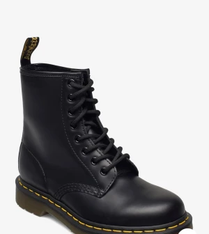 Svarta boots från Dr. Martens - Klassiska svarta boots från Dr. Martens med snörning och rund tå. Tillverkade i slätt skinn med den ikoniska gula sömmen runt sulan.  Skorna är använda 3 gånger så är som nya. Säljs då de inte kommer till användning. Skriv för fler bilder 