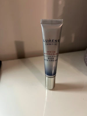 Lumene Arctic Hydra Care Eye Cream - Fuktgivande och lugnande ögonkräm från Lumene, Arctic Hydra Care-serien. Kommer i en silverfärgad tub med blå detaljer och skruvkork i plast. Perfekt för att återfukta området runt ögonen. Innehåller 15 ml. Aldrig använd och är oöppnad 