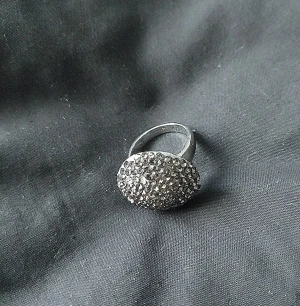 Glittrig silverring med stenar - Säljer en rund, glittrig ring i silverfärg med massor av små gnistrande stenar på ovansidan. Ringen har en tydlig statement-look och passar perfekt för dig som vill sticka ut med accessoarerna. Supersnygg att matcha med andra smycken för en extra glam känsla.