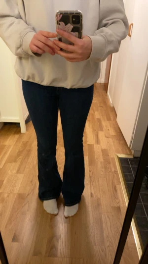 Mörkblå bootcut jeans - Snygga mörkblå jeans med bootcut passform som ger en schysst siluett och är högmidjade. Köpa från lager för 400kr och har storlek M. 