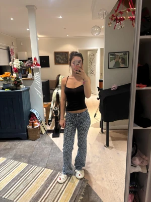 Blommiga blå bootcut jeans - Säljer ett par blå bootcut jeans från H&M med blommigt mönster i ljusblått. Midrise