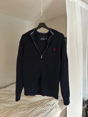  Polo Ralph Lauren full zip - Riktigt snygg marinblå kofta från Polo Ralph Lauren. Riktigt skön tröja att dra på sig när de börjar bli lite kyligare eller att ha utanpå skjortan. Den är storlek L men sitter mer som en M. 
