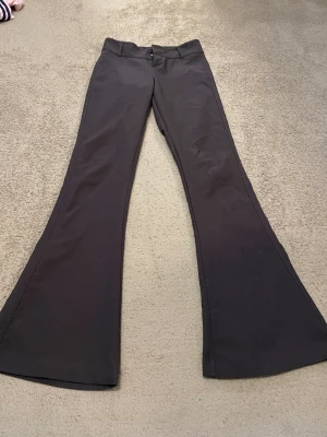 Utsvängda mörkgråa byxor  - Snygga utsvängda mörkgråa byxor. Ytterbenslängd 103, innerbenslängd 79, midjemått 33. Inga skador. 💕