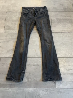 Mörkblå bootcut jeans - Snygga mörkblå jeans med klassisk bootcut passform. Jeansen har fem fickor, normal midja och kontrastsömmar. Tillverkade i slitstarkt denimtyg som ger en tidlös look. Perfekta för dig som gillar en avslappnad men ändå stilsäker vibe.