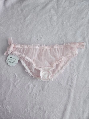 Rosa trosor med rosetter - Helt nya med tags. Står storlek M men uppskattar att dom passar XS-S. 