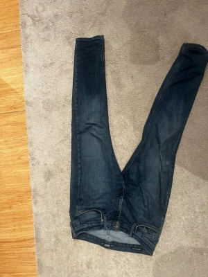 Mörkblå Jack n Jones  jeans - Säljer ett par fräscha jeans som sitter perfekt på varenda outfit. . Jeansen har en bekväm passform och är tillverkade i stretchigt denimtyg för extra komfort. De är w28 , L 32 i storlek.Det är bara att höra av er vid dm ev frågor eller funderingar!