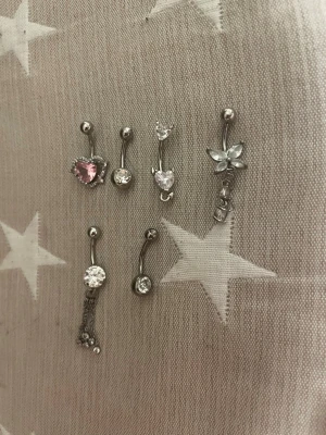 Navelpiercing - Säljer dessa navelpiercingar på övre raden kostar dem 60kr styck och innehåller nickel som kan irritera om man är allergisk på nedre raden är allergi vänliga och den längst ner utan kedjor är läksmycke så den är lite längre dem kostar 100kr styck inget tecken på användning en har tappt en sten men man kan ba byta pris kan diskuteras och bli billigare om man köper flera 