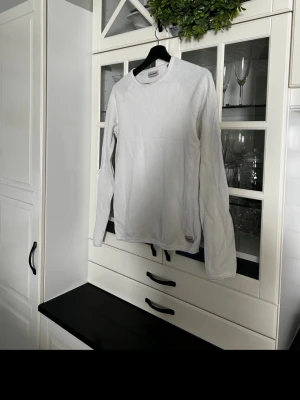 Vit långärmad tröja Jack & Jones XS - Vit långärmad tröja från Jack & Jones i storlek XS. Tröjan har en rund halsringning och är tillverkad i ett strukturerat bomullsmaterial som ger en snygg och enkel look. Perfekt för dig som gillar stilrena och bekväma plagg.