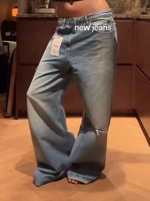 Ljusblå baggy jeans med slitningar - Säljer ett par ljusblå baggy jeans från Zara med medelhög midja. Jeansen har breda ben, slitningar på framsidan och en riktigt avslappnad vibe. Tillverkade i klassiskt jeansmaterial och perfekta för dig som gillar en loose och trendig stil. Helt nya endast testade, säljer då jag inte kunde skicka tillbaka, prislappen kvar. Det passade inte mig därför har jag tyvärr inga egna bilder.🎀 (hör av er via frågor)