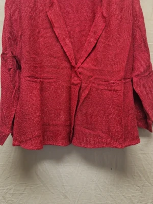 Vinröd kavaj från Masai, storlek M - Säljer en vinröd kavaj från Masai i storlek M. Jackan har en avslappnad passform, långa ärmar och är tillverkad i ett grovt, stickat material. Klassisk krage och enkel knapp framtill ger en chill och unik look.