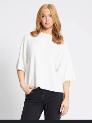 Vit oversized stickad topp - Säljer en vit  stickad tröja med trekvartsärmar och rund hals. Perfekt för dig som gillar en avslappnad och trendig stil. Enkel att matcha med både jeans och kjol