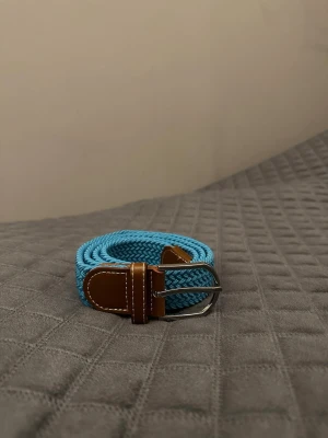 Turkost flätat bälte - Tja det är helt nytt från Bältgallerian. Det är 105cm långt och 3,5vm brett. Det är i ett elastiskt material så passar större storlekar. Vid köpa av flera minskad priset.