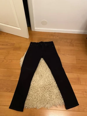 Svarta Levi's 511 jeans skinny fit - Svarta Levi's 511 jeans med skinny passform. Klassisk femficksmodell med Levi's-logga på bakfickan och svart patch bak i midjan. Snygg, smal siluett och stretchigt jeanstyg som sitter tajt längs benen. Perfekta för dig som gillar en clean och stilren look.