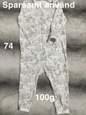 Vit pyjamas med djurmönster, stl 74 - Mysig vit pyjamas med dragkedja och detaljerat mönster av ekorrar och växter. Långärmad och helkropp, perfekt för små äventyrare. praktisk dragkedja som går hela vägen ner för enkel påklädning.🌸 Sparsamt använd. Storlek 74