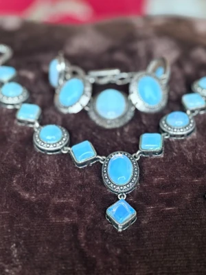 Jätte fin smyckesset 🩵 - Bildeett smyckeset med halsband och armband i silverfärgad metall med ljusblå stenar, men ingen väst finns med.