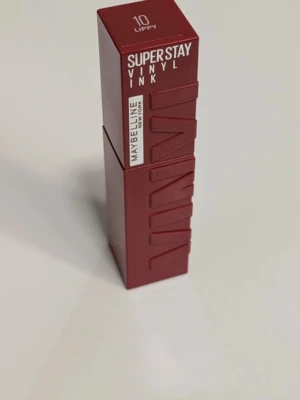 Maybelline Super Stay Vinyl Ink Lippy - Maybelline Super Stay Vinyl Ink i nyansen 10 Lippy. Ett flytande läppstift med intensivt rödbrun färg och glansig finish. Kommer i en stilren fyrkantig förpackning i matchande färg. Perfekt för dig som vill ha långvarig färg med vinylglans. Endast testad på handryggen 