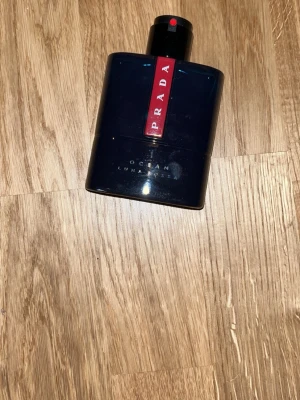 Prada Luna Rossa Ocean parfym - Stilren och modern parfym från Prada med cool blå flaska och röd detalj. Perfekt för dig som vill ha en exklusiv touch i din doftsamling. Volym och ingredienser syns ej på bilderna.100ml