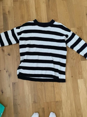Randig stickad tröja från Selected Femme - Säljer en svartvit randig stickad tröja från Selected Femme i storlek XS. Tröjan har breda horisontella ränder, ribbade muddar och lång ärm. Perfekt för dig som gillar en klassisk men ändå chill look.