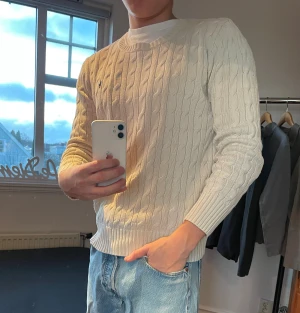 Vit kabelstickad tröja från Polo Ralph Lauren - Polo Ralph Lauren Cableknit | Märkt L men passar bäst S | Vit med ljusblå logga | Skick 8/10 | Fräsch och tidlös kabelstickad tröja – perfekt för en clean preppy look | Nypris ca 1500–2000 kr | ✅ Äkta vara | 📩 Öppen för frågor | 🚚 Skickas inom 24 timma