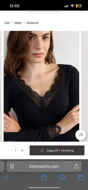 Svart långärmad topp med spets från Intimissimi - Svart långärmad topp från Intimissimi med djup v-ringning och breda spetsdetaljer längs halsringning och ärmslut. Topp i mjukt material som sitter snyggt och har en feminin touch tack vare spetsen.