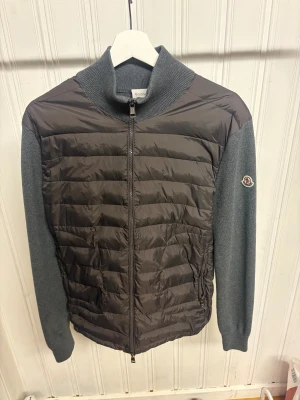 Grå Moncler cardigan jacka med dragkedja - Snygg grå cardigan jacka från Moncler.                        Använd några få gånger då jag tyckte den va för liten för mig.                                                                Storlek L.                                                                           