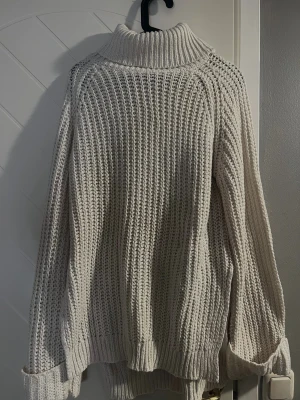 Vit/beige stickad  med grov struktur - Säljer en vit/beige stickad med grov struktur. Tröjan har en bred, ribbad polokrage.