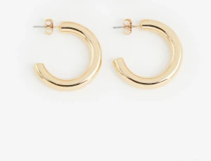 Guldiga chunky hoops örhängen - Snygga och trendiga chunky hoops i guldton. Örhängena har en rund, tjock form och stängs med klassisk plopp. Perfekta för dig som gillar statement-smycken och vill addera lite extra glans till din look.