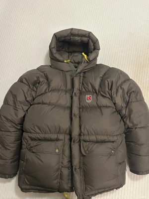 Fjällräven Expedition Jacka - Säljer en olivgrön dunjacka från Fjällräven (expedition) i storlek XS. Enda defekten är en liten rispa på ena armen, men påverkar ej användningen samt att den knappt syns. Väldigt fint skick