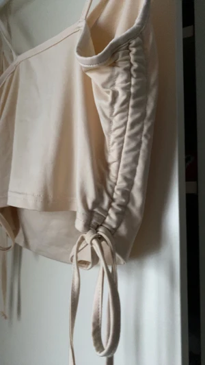 Beige och svart linnetopp med snörning - Två toppar i beige och svart med smala axelband och  snörning på sidorna. Topparna har croppad passform och lätt draperad front. Går att justera i midjan. Stl M/38 från SHEIN.