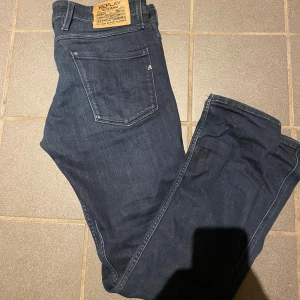 Replay mörkblå jeansbyxor - Snygga mörkblå jeans från Replay med klassisk femficksdesign och tydlig Replay-lapp bak i midjan. Jeansen har raka ben och är tillverkade i mjukt denim-material som sitter skönt hela dagen. Perfekt för dig som gillar stilrena och tidlösa jeans. Hör av dig vid funderingar! 🤩