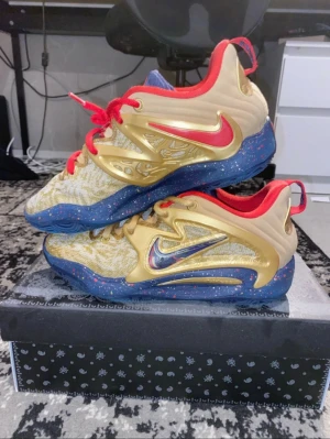 Nike KD 15 sneakers guld/blå/röd - Har använt dom i mindre än ett år, har ingen lukt i sig har ett litet slit märke som man knappast ser. Dom är i mycket bra skick. Om du vill sänka priset kan vi prata om det annars skicka ett bud på har även samma fast i storlek i 41 som också säljs